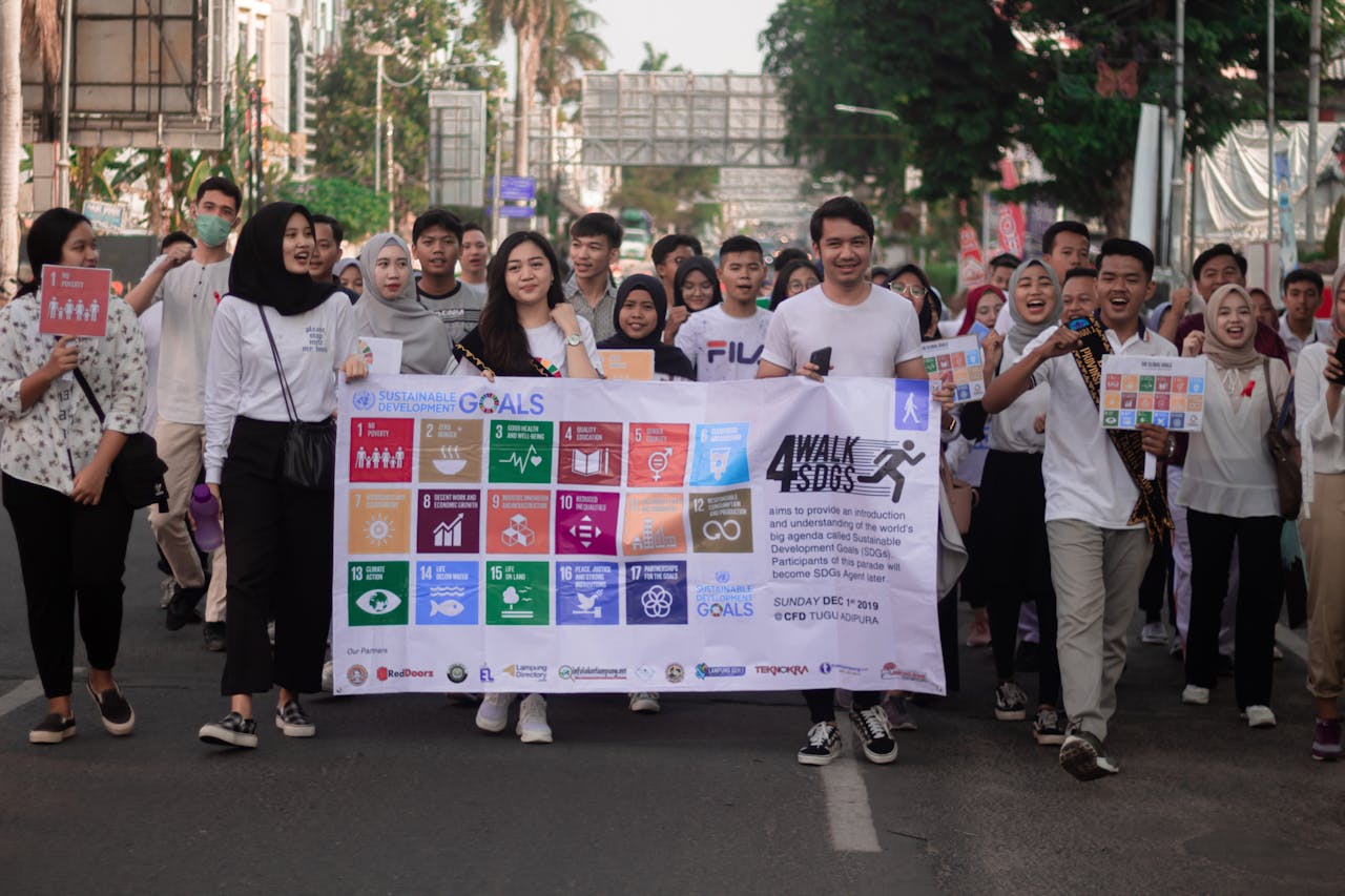 People holding a banner with the UN SDGs